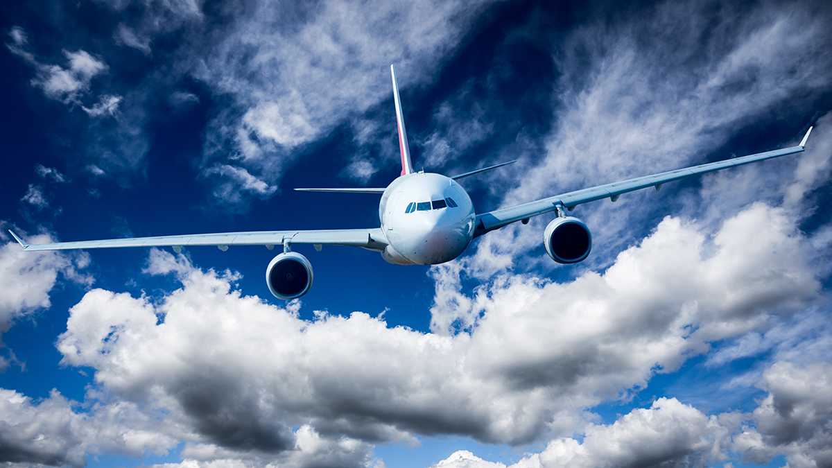 Flygplanlandning i en halvmolnig himmel.