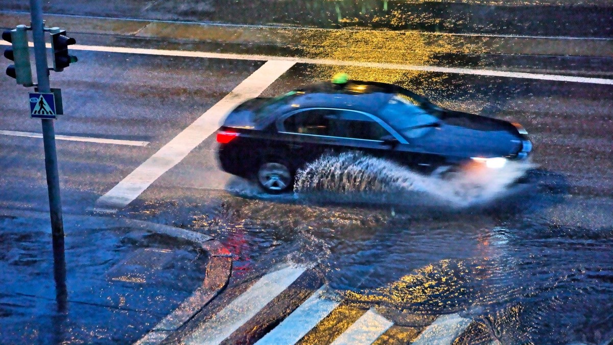 Bilden visar en bil som kör i regn.