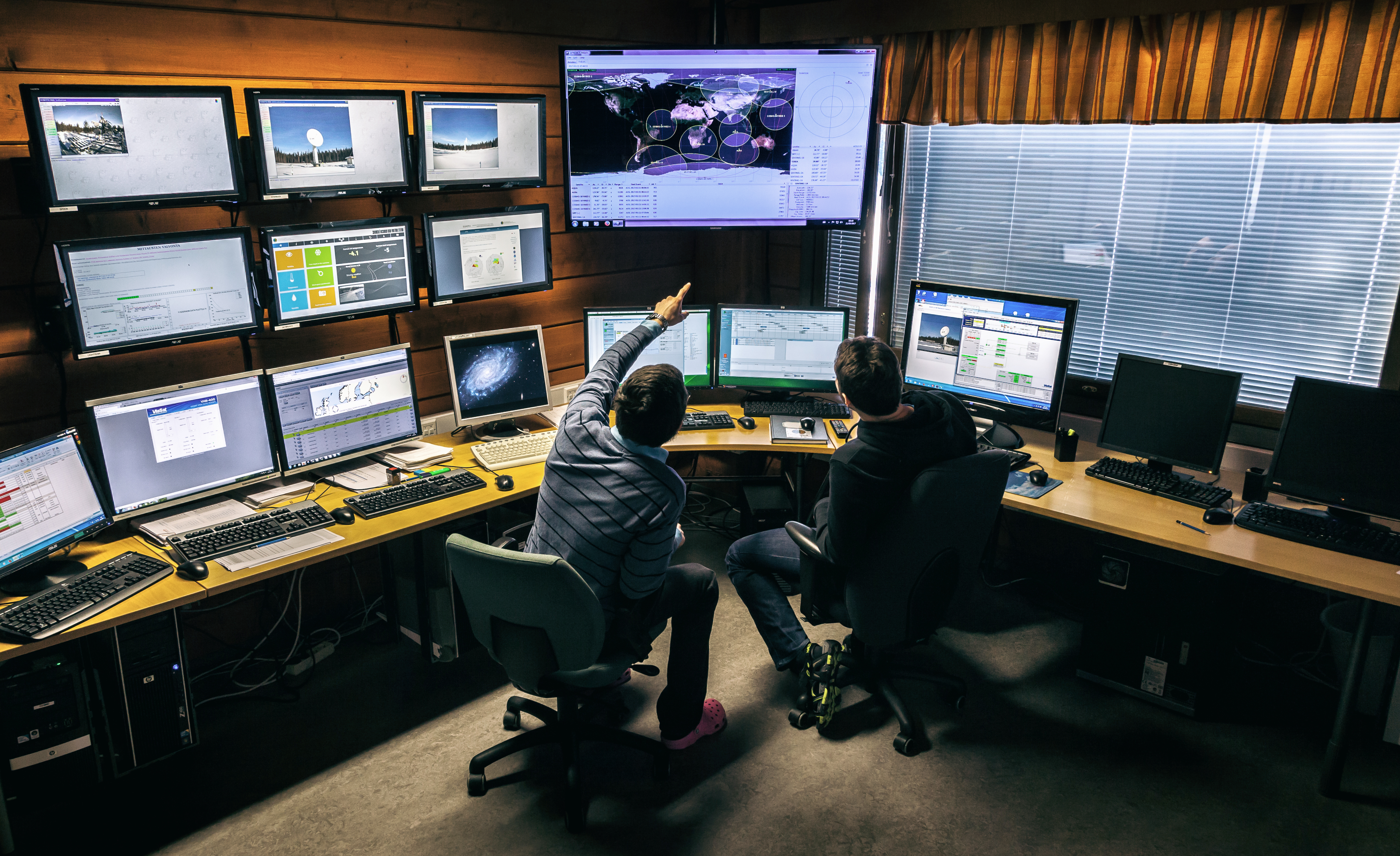 Bilden visar människor framför monitorer.