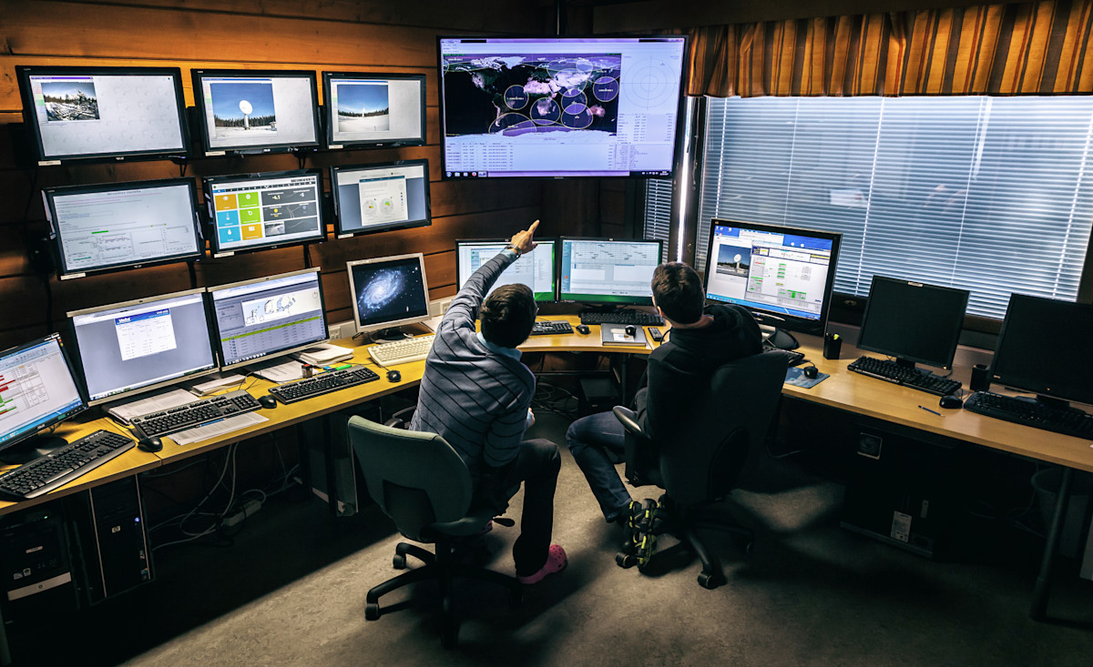 Bilden visar människor framför monitorer.